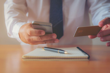Businessmen holding credit cards print details online shopping.