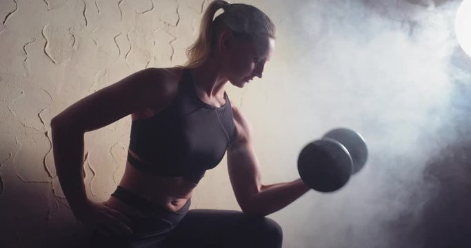 Athletic beautiful girl doing workout with weights. Home workouts