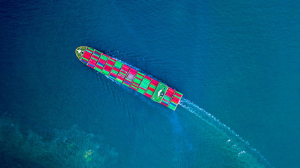 Container ship carrying container for import and export, Aerial view business logistic and freight transportation by ship in open sea.