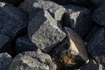 Stone setts laid on a pile. The gray stone paving kosta prepared for the laying of sidewalks