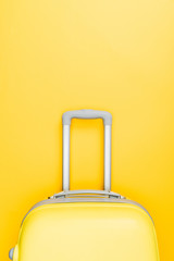 top view of travel bag with handle on yellow background