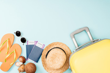 top view of straw hat, coconut, flip flops, seashells, sunglasses, passports, air tickets and...