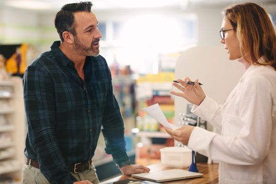Pharmacist explaining a prescription to customer