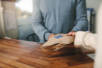 Pharmacist giving prescribed medicine to customer in pharmacy