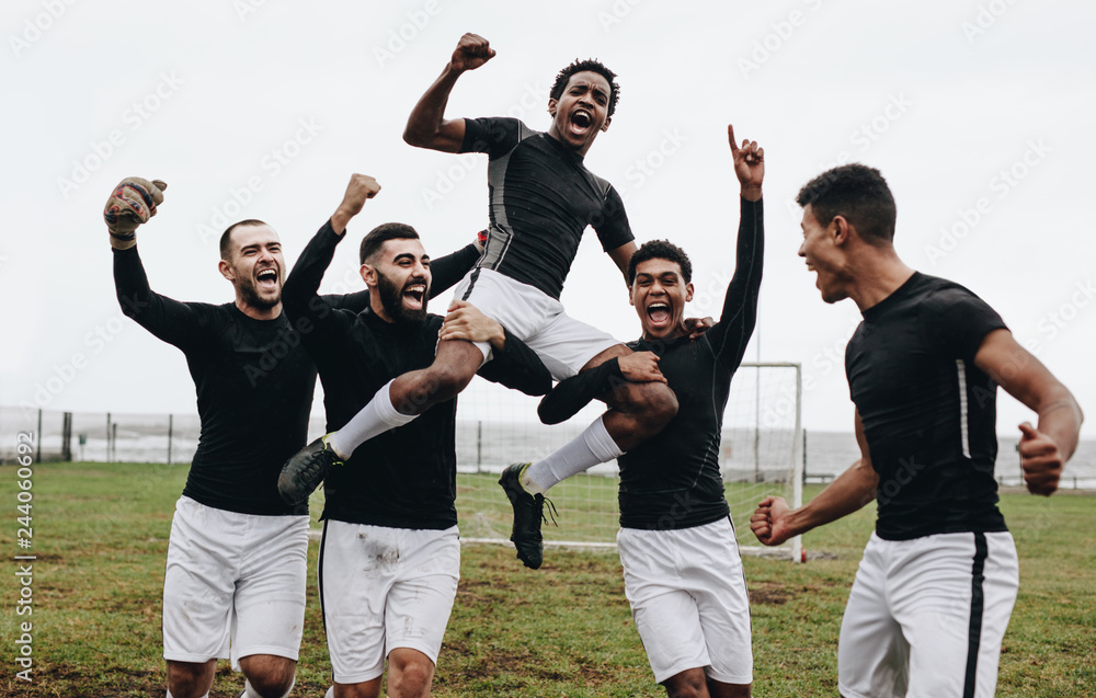 Wall mural Footballers celebrating success on field