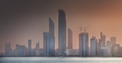 View of Abu Dhabi Skyline at misty sunrise, UAE