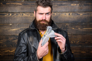 Man brutal bearded hipster wear leather jacket and hold cash money. Man give cash money bribe....
