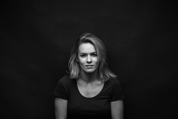 Dramatic black and white portrait of a beautiful woman on a dark background