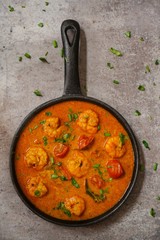 Homemade shrimp curry / Curried prawns in a skillet overhead view