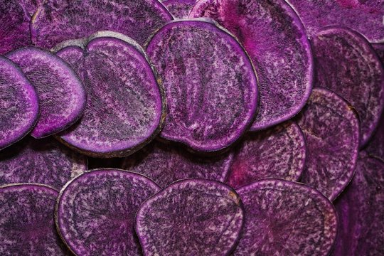 Purple potatoes sliced background in full frame