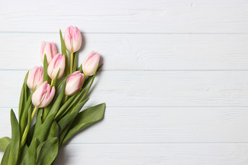 A bouquet of tulips on a wooden background top view. Spring background. Background to Mother's Day, International Women's Day, birthday.