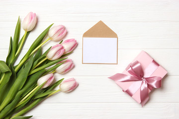 beautiful tulips bouquet, gift and card for text on wooden background top view. Mother's Day Background, International Women's Day, Birthday. Holiday, give a gift.