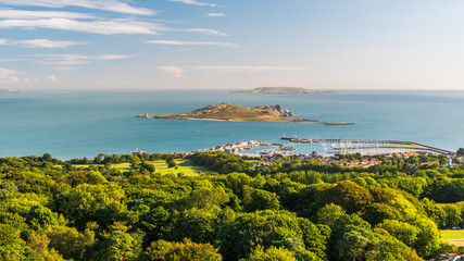 Irish landscape as seen from the Ben of Howth with green trees, turquoise sea waters and Ireland's...