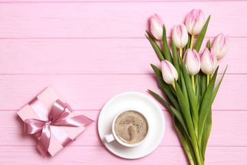 bouquet of beautiful tulips, gift and coffee on wooden background top view. Mother's Day Background, International Women's Day, Birthday. Holiday, give a gift.