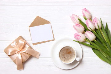 bouquet of beautiful tulips, gift and coffee on wooden background top view. Mother's Day Background, International Women's Day, Birthday. Holiday, give a gift.