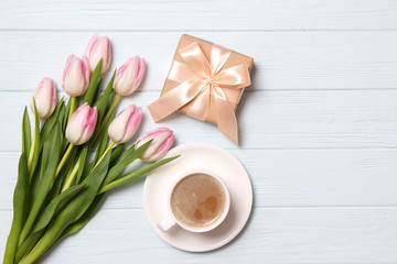 bouquet of beautiful tulips, gift and coffee on wooden background top view. Mother's Day Background, International Women's Day, Birthday. Holiday, give a gift.