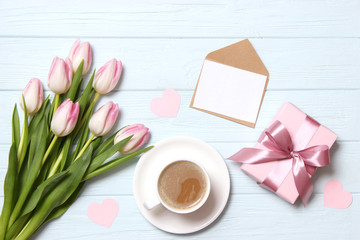 bouquet of beautiful tulips, gift and coffee on wooden background top view. Mother's Day Background, International Women's Day, Birthday. Holiday, give a gift.