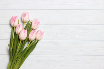 Obraz na płótnie Canvas A bouquet of tulips on a wooden background top view. Spring background. Background to Mother's Day, International Women's Day, birthday.