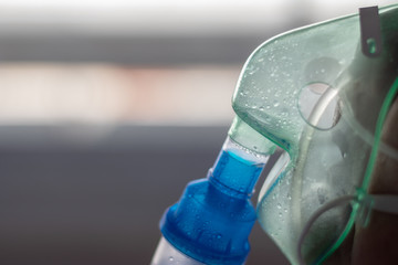 Old man holds mask inhaler treatment of asthma. breathing through a steam nebulizer
