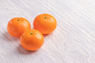 Ripe moroccan tangerines on a white wooden table.