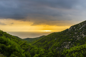 Greece, Zakynthos, Spectacular orange burning dramatic sky and beautiful green valley to the ocean