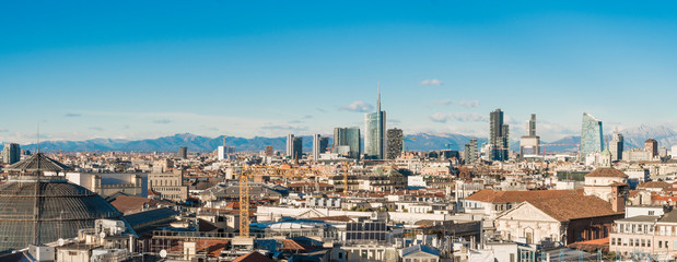 Milan skyline. Large panoramic view of Milano city, Italy. The mountain range of the Lombardy Alps...