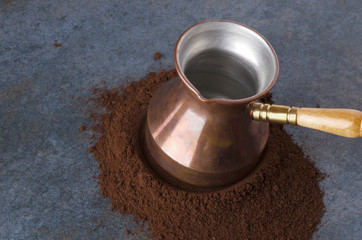 Ground coffee,turkish coffee pot,grey table,closeup