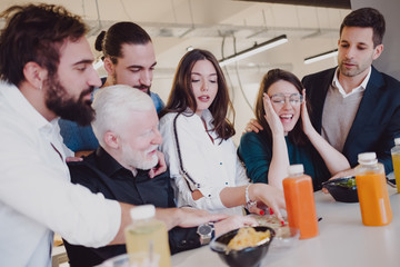 Smiling coworkers looking at the menu in the cafeteria
