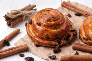 Tasty buns with raisins and cinnamon on a white wooden background. fresh bakery. breakfast.
