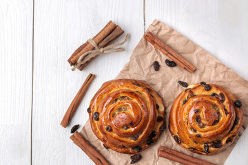 Tasty buns with raisins and cinnamon on a white wooden background. fresh bakery. breakfast. view from above