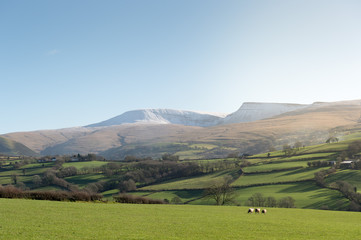 landscape with green hills, blue sky and snoowy mountains )brecon beacons national park)
