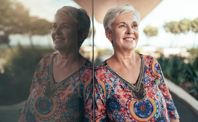 Portrait of a beautiful grey haired middle aged woman looking out into the distance with her...