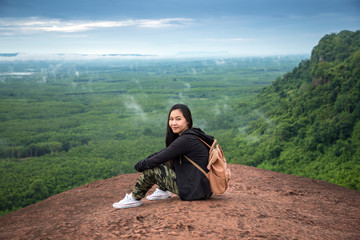 Naklejka na ściany i meble Young woman sitting on a mountain top
