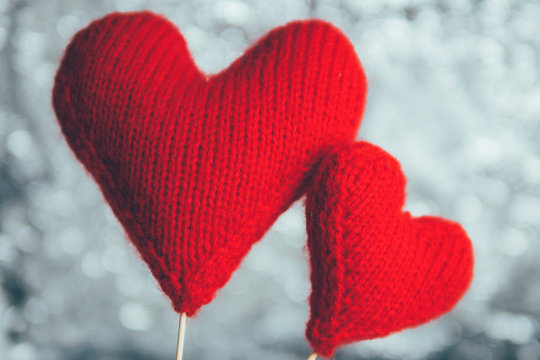 Two soft knitted red hearts background