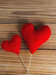 Two soft knitted red hearts background