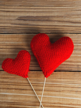 Two soft knitted red hearts background