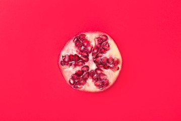 pomegranate fruit slice isolated on red background.