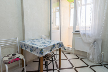 A small kitchen table stands near the balcony