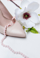 1 white women's boat Shoe, pink pearl necklace, Magnolia flower