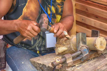 The man is working wood. It is a craft.