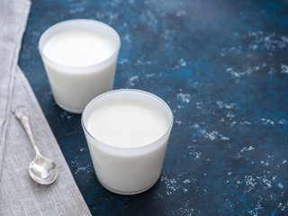 Healthy breakfast. Yogurt in white glasses on a blue background. Copy space