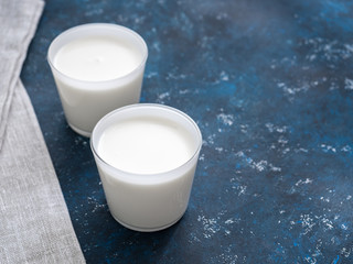Healthy breakfast. Yogurt in white glasses on a blue background. Copy space