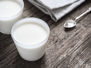 Healthy breakfast. Yogurt in white glasses on wooden background. Copy space