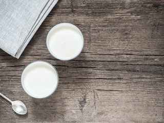 Healthy breakfast. Yogurt in white glasses on wooden background. Copy space, flat lay, top view