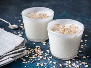 Healthy breakfast. Yogurt with oat flakes in white glasses on a blue background.