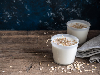 Healthy breakfast. Yogurt with oat flakes in white glasses on a wooden table