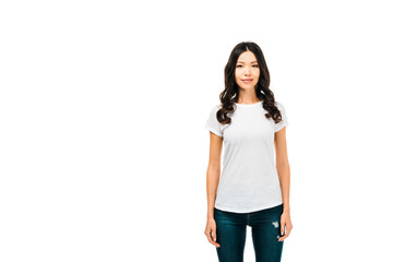 attractive young woman in white t-shirt standing and smiling at camera isolated on white