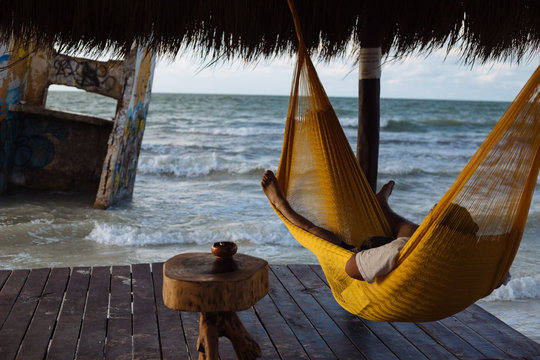 Man relaxing in hammock near sea