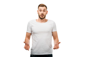 confused young man gesturing with hands and looking at camera isolated on white