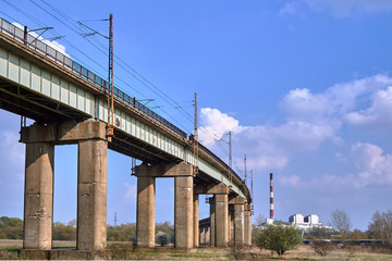 A flyover with a railway line and a chimney of a heat and power plant near Poznań.